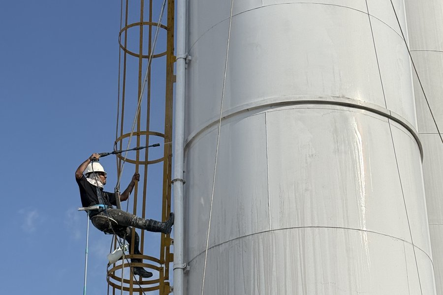 Técnico em acesso por corda durante limpeza de silo industrial
